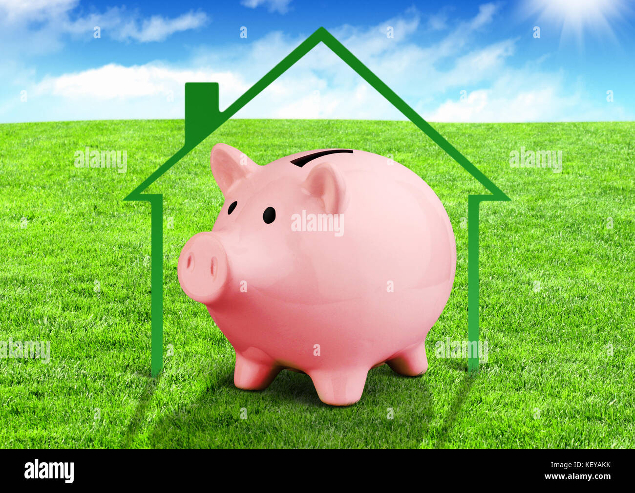 Einsparungen für ein Haus Konzept, Sparschwein auf grünem Feld Stockfoto