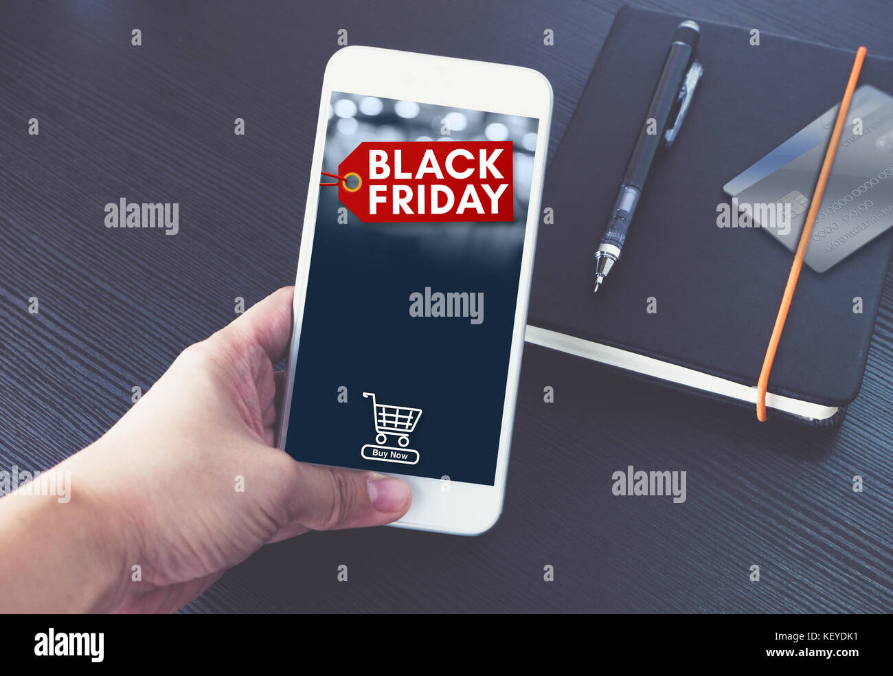Schwarzer Freitag verkauf Variable mit Warenkorb auf mobilen Bildschirm, Hand, smart phone über schwarzen Buch und Kreditkarte online in Apps, Shop, e-commerce c Stockfoto