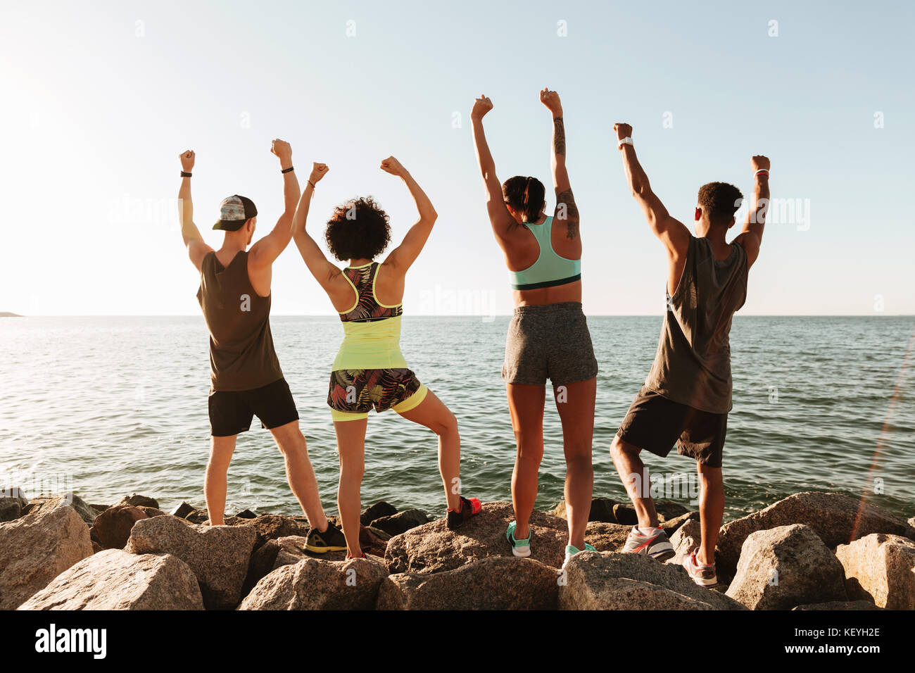 Zurück Blick auf vier happy Fitness freuen sich nach dem Training in der Nähe des Meeres Stockfoto