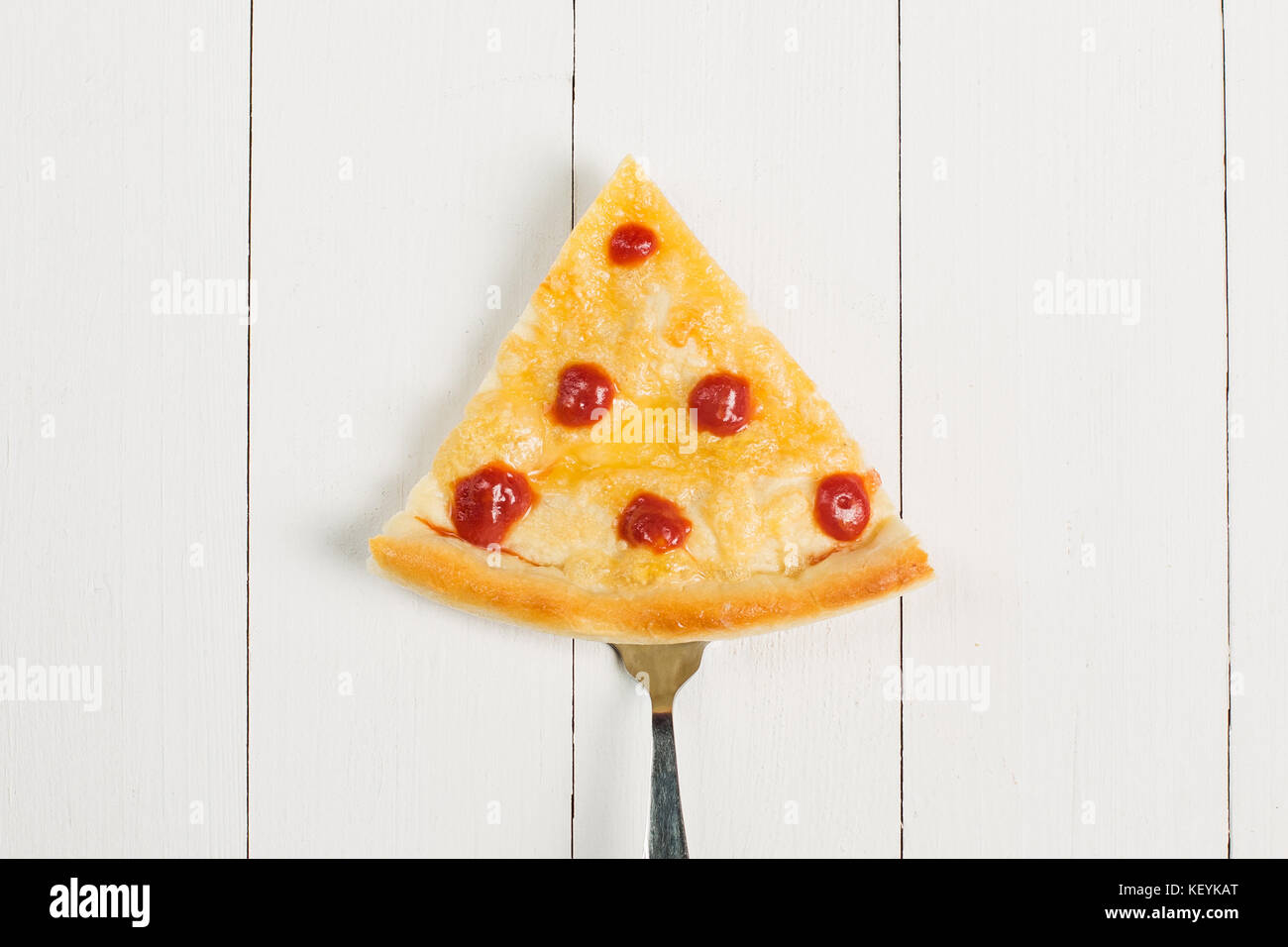 Stück Pizza auf eine Gabel auf einem hölzernen Hintergrund Stockfoto