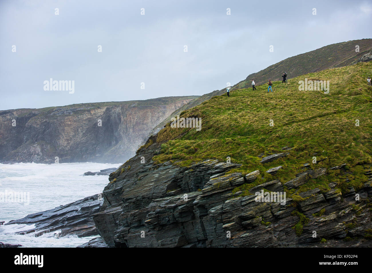 Die Leute, die Fotos auf der Klippe bei Trebarwith Strand in Cornwall vor dem Sturm Brian der Küste hits Stockfoto