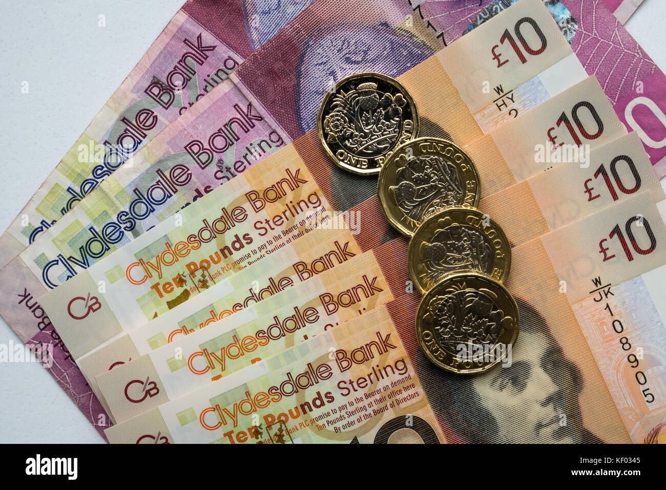 Clydesdale Bank Schottischen 20 £ 20, Kunststoff Polymer 10 £ 10 Banknoten mit Robert Burns und Sechskant ein Pfund £ 1 Münzen auf weißem Hintergrund Stockfoto