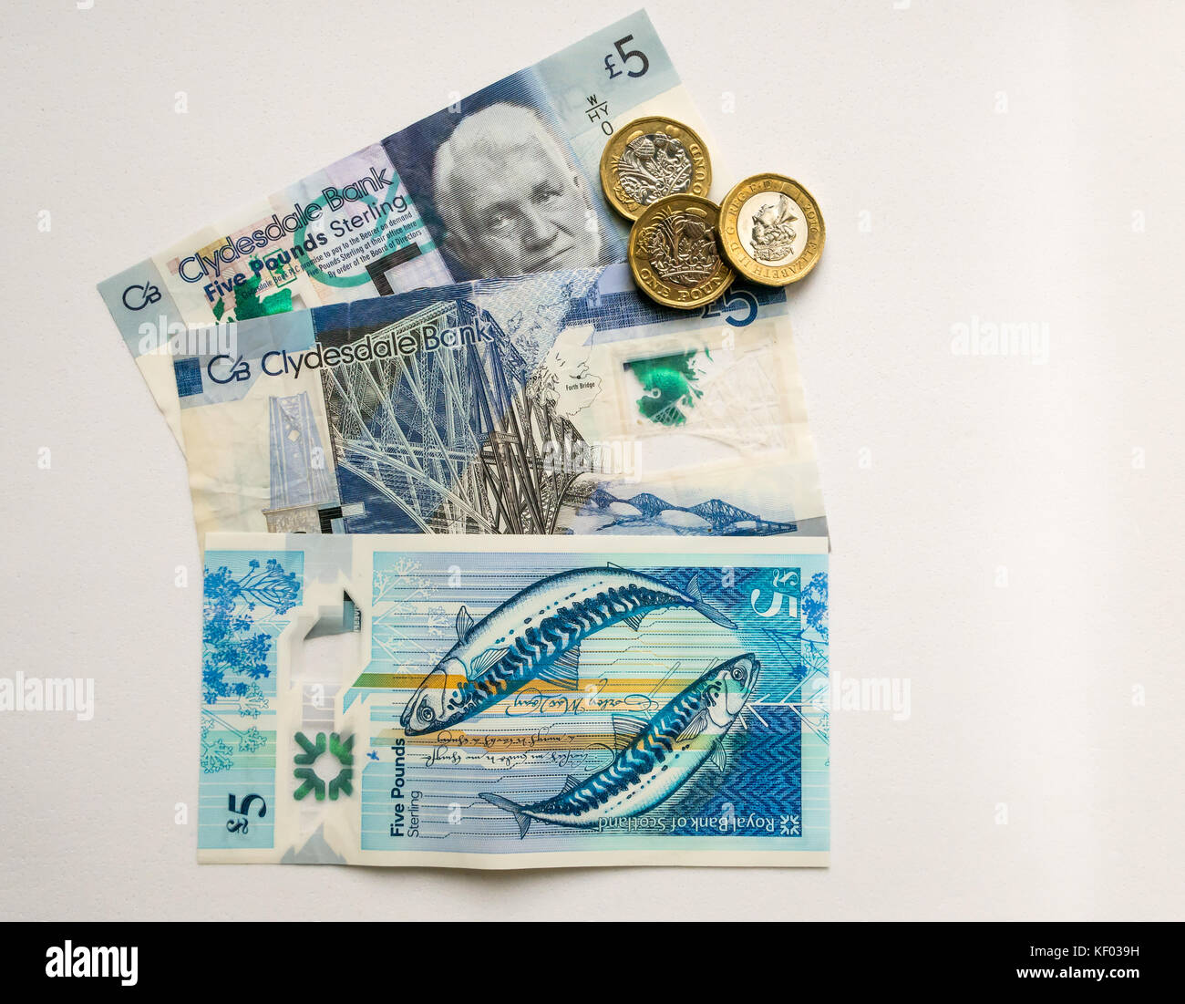 Sechseckige £ 1 Münzen und Polymer Schottischen £ 5 fünf Pfund Banknoten, Clydesdale Bank und Royal Bank of Scotland, mit zwei Makrelen durch Künstler Stuart Kerr Stockfoto