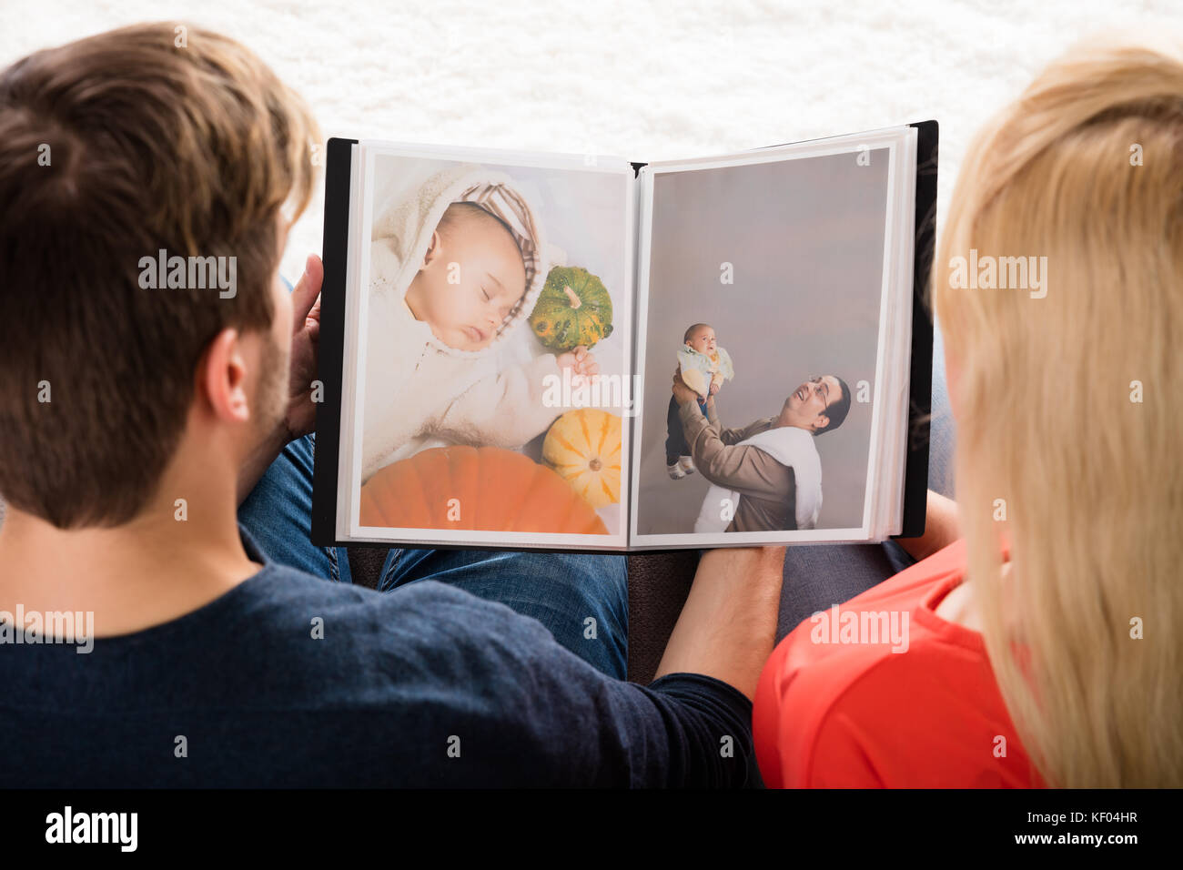 Hochwinkelansicht Des Jungen Paares Beim Betrachten Des Fotoalbums Stockfoto