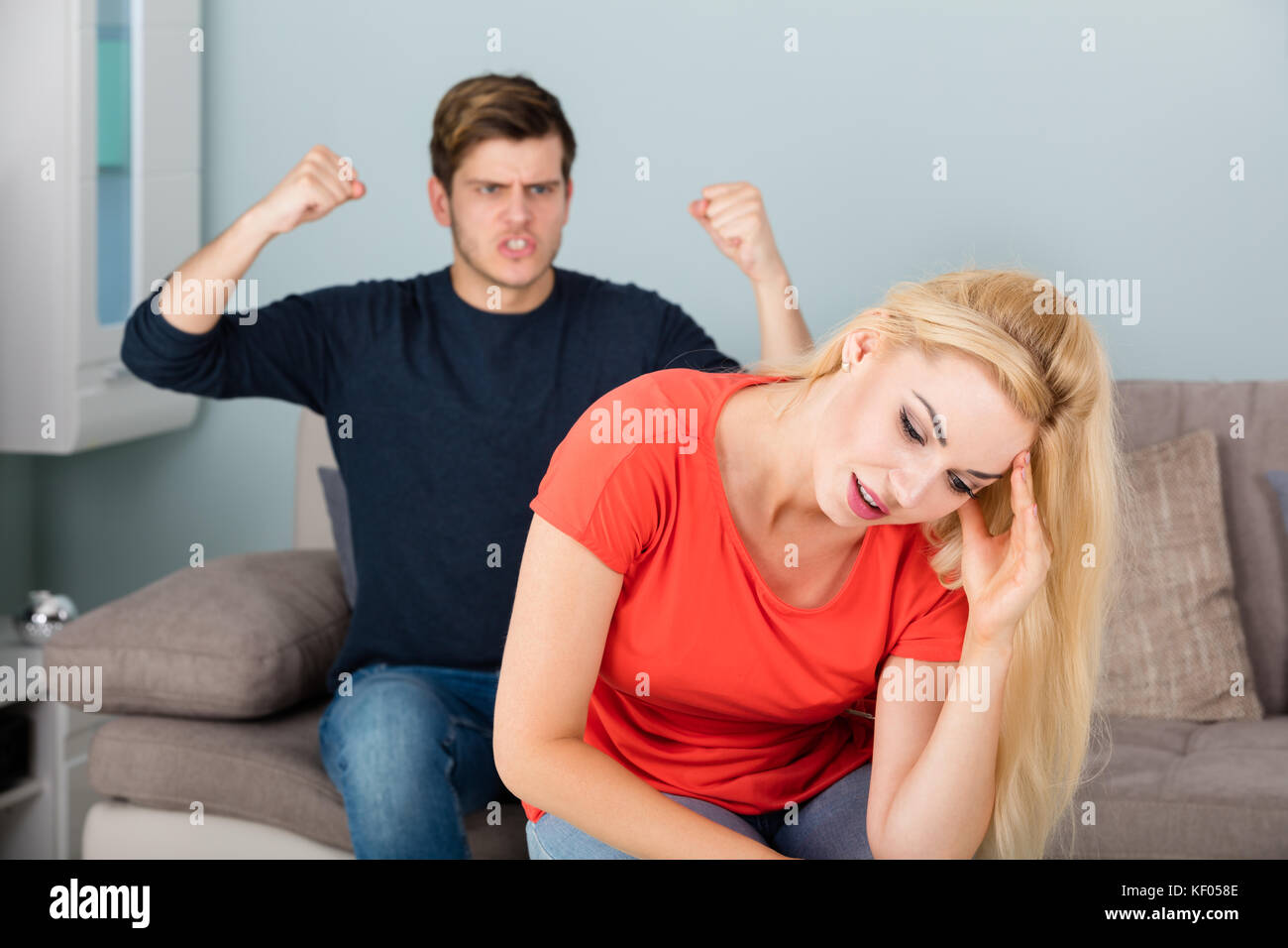 Wütender Junger Mann, Der Seine Frau Über Scheidung Und Untreue Im Wohnzimmer Anruft Stockfoto