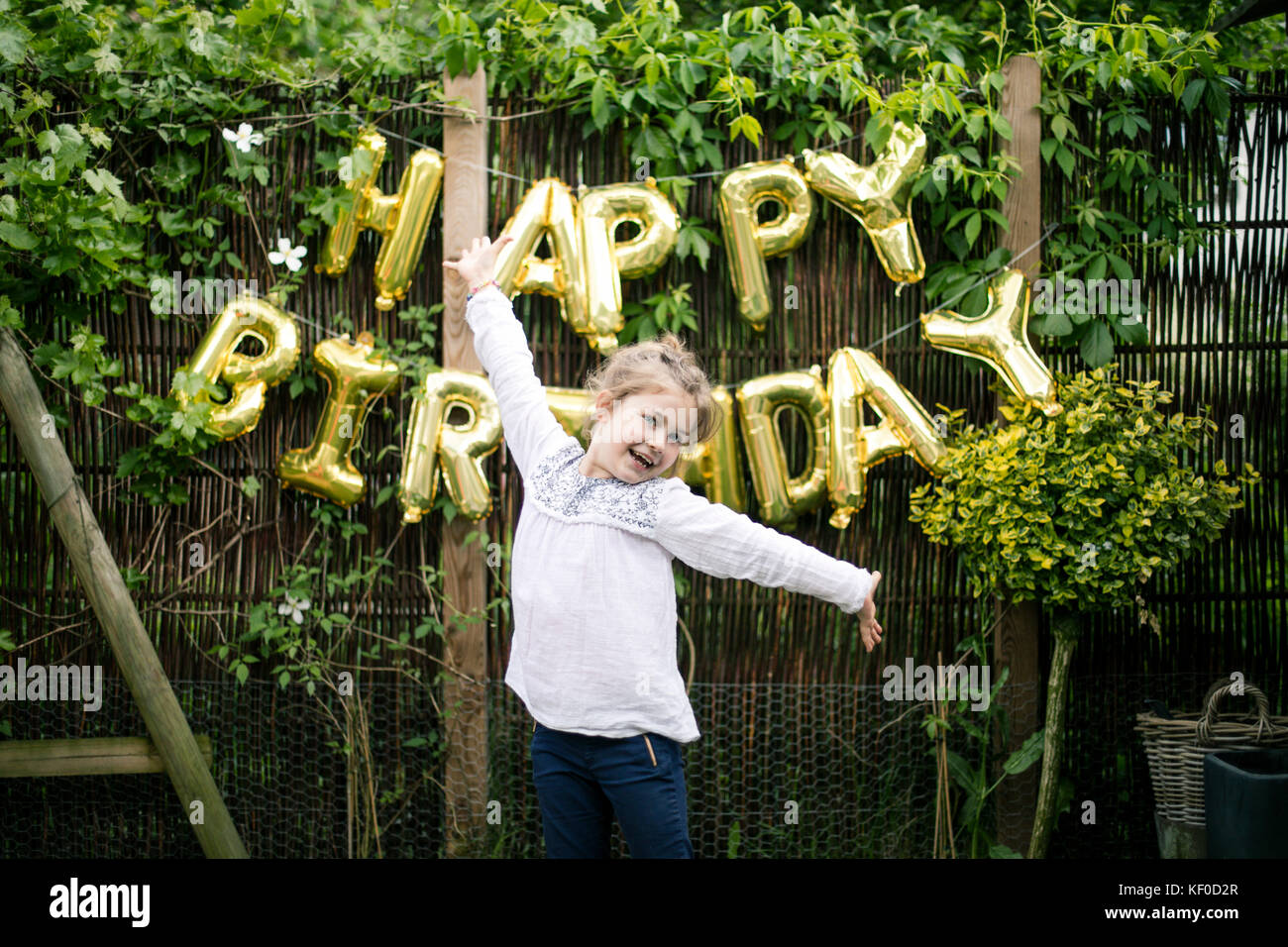 Porträt von Mädchen im Garten mit Dekoration für Geburtstagsfeier im Hintergrund Stockfoto