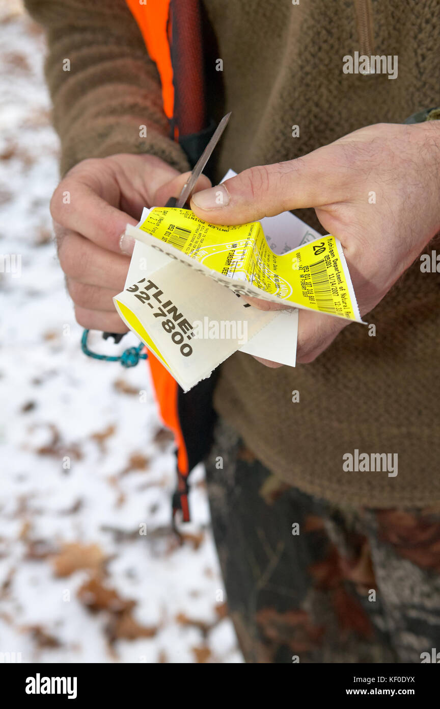 Jäger mit einem sammelanschluss Quote-Tag in seine Hände auf schneebedeckten Boden in Nahaufnahme der Dokumentation Stockfoto