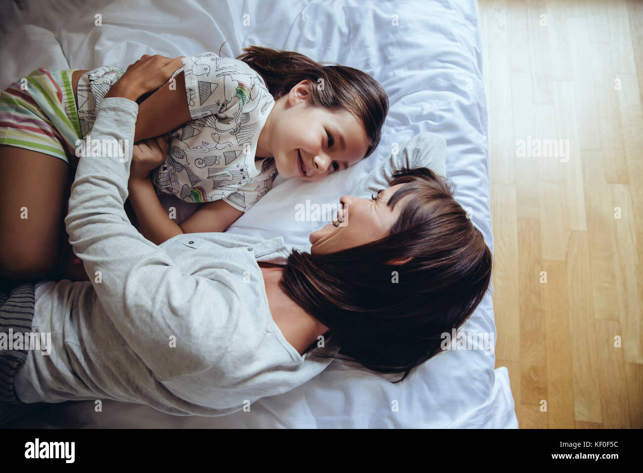 Mutter und Tochter kuscheln auf dem Bett Stockfoto