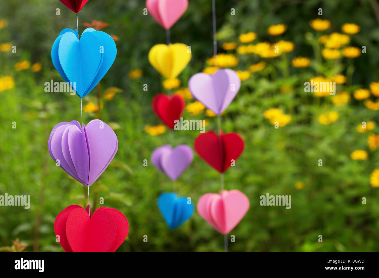 Heart-shaped Girlanden aus Papier hängen im Garten, close-up Stockfoto