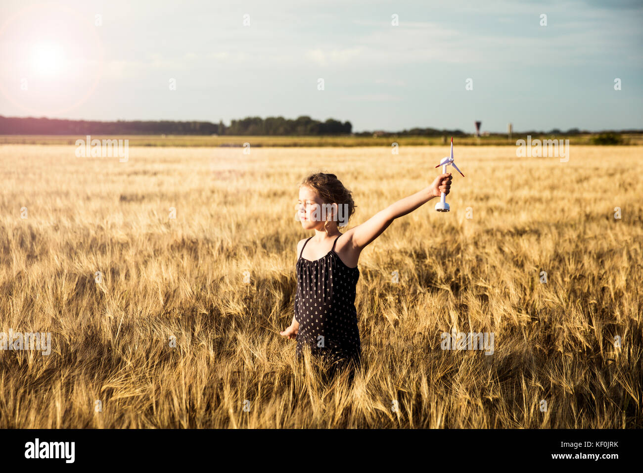 Stehendes Mädchen im Feld Struktur holding Miniatur Wind Turbine Stockfoto