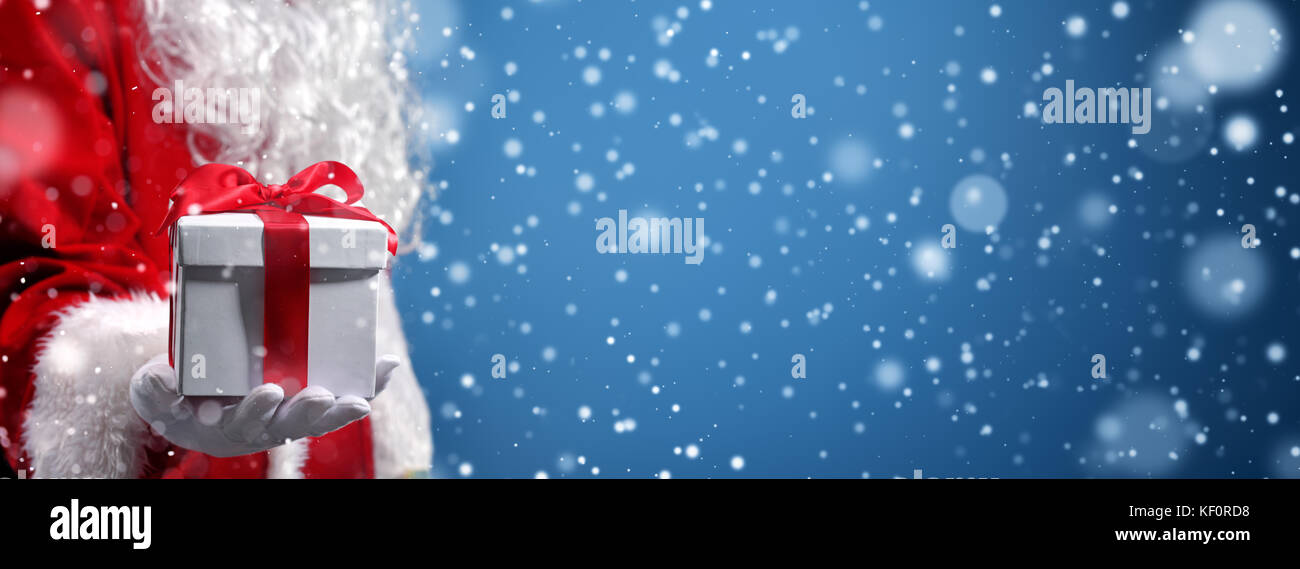 Santa claus Holding Geschenkboxen im Schnee Stockfoto