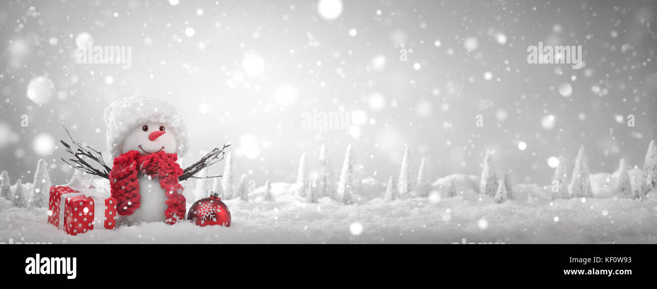 Schneemann mit Geschenk zu Weihnachten im Schnee Stockfoto
