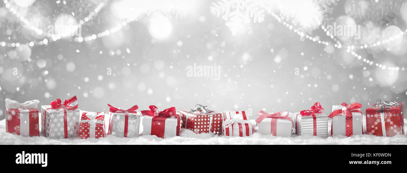 Zeile der Weihnachtsgeschenke auf Schnee Stockfoto