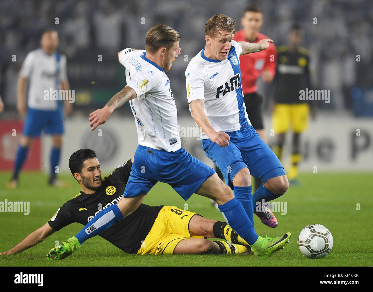 Der Dortmunder Nuri Sahin (l) um den Ball gegen die Magdeburger Philip turpitz und Richard weil (r) während der dfb-pokal Fußball Match zwischen dem 1.FC Magdeburg und Borussia Dortmund in der mdcc-Arena in Magdeburg, Deutschland, 24. Oktober 2017. (Embargo Bedingungen - Achtung: Der dfb verbietet die Nutzung und Veröffentlichung der sequenziellen Bilder auf das Internet und andere Onlinemedien während des Spiels (einschließlich der Halbzeit). Achtung: Sperrfrist! Der dfb erlaubt die weitere Nutzung und Veröffentlichung der Bilder für mobile Dienste (insbesondere mms) und für dvb-h und dmb nur nach der e Stockfoto