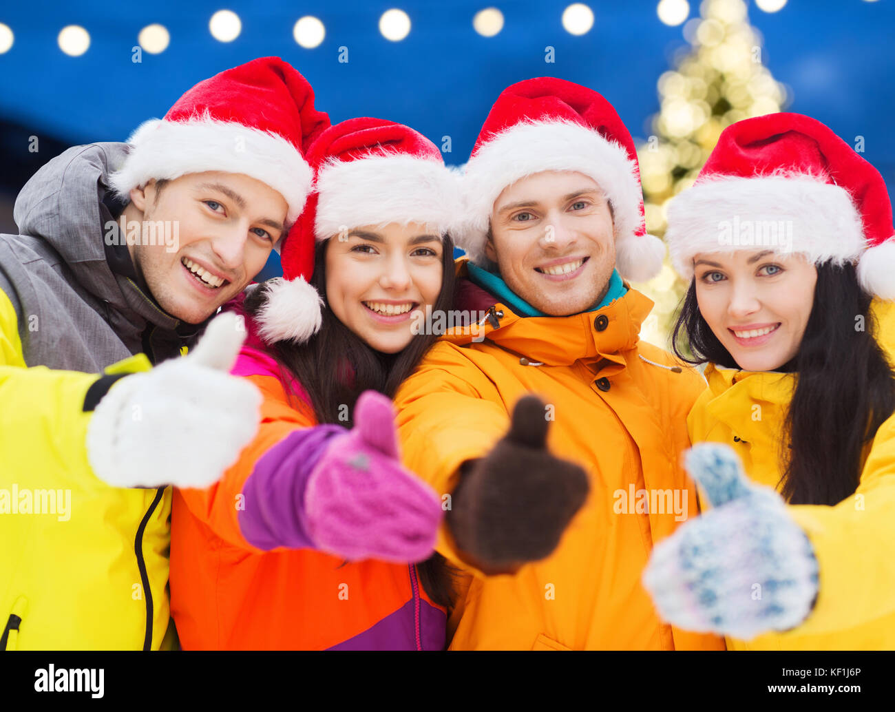 Glückliche Freunde in Santa Hüte und Skianzüge im freien Stockfoto