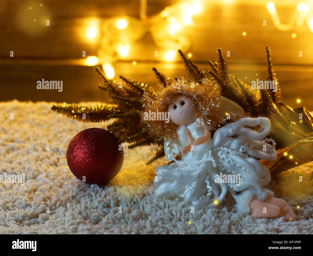 Kleines Spielzeug Engel und Weihnachtsbaum Spielzeug red ball gegen die festliche Girlande. Stockfoto