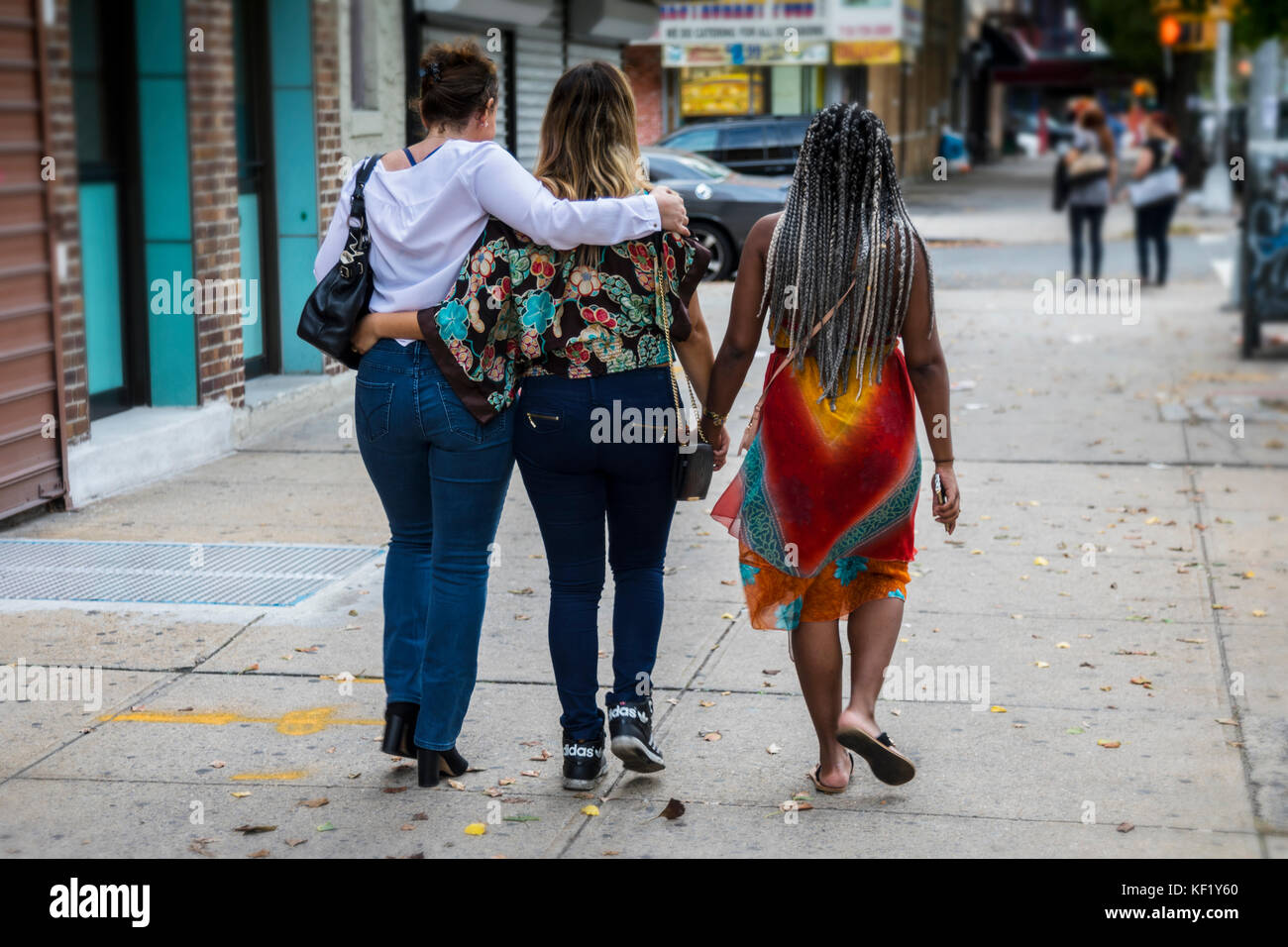 Drei Mädchen halten sich an den Händen zu Fuß auf der Straße, New York Stockfoto
