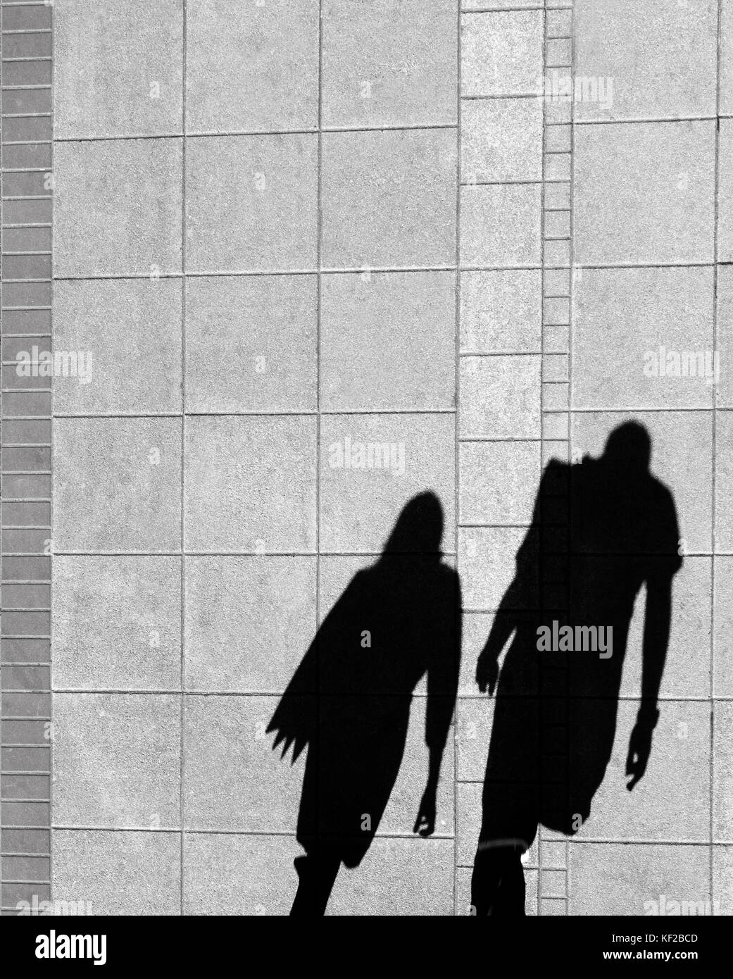 Schatten von einer Frau und einem Mann, die auf Stadt Bürgersteig von oben in Schwarz und Weiß Stockfoto