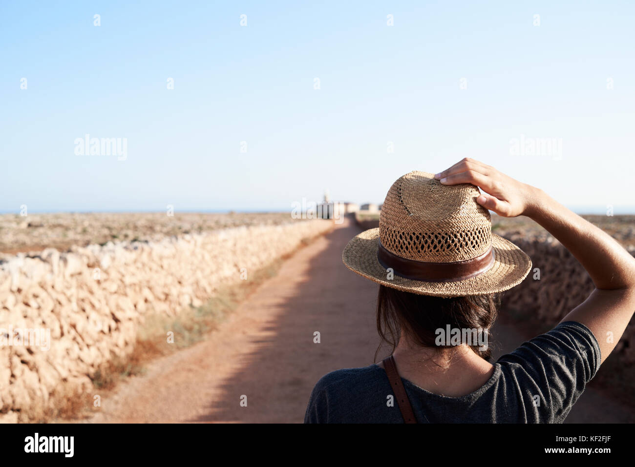 Menorca, Spanien, Alleinreisende Blick von hinten mit einem Explorer hat in einem leeren Straße zu einem Leuchtturm der Insel Menorca, solo Traveler Stockfoto