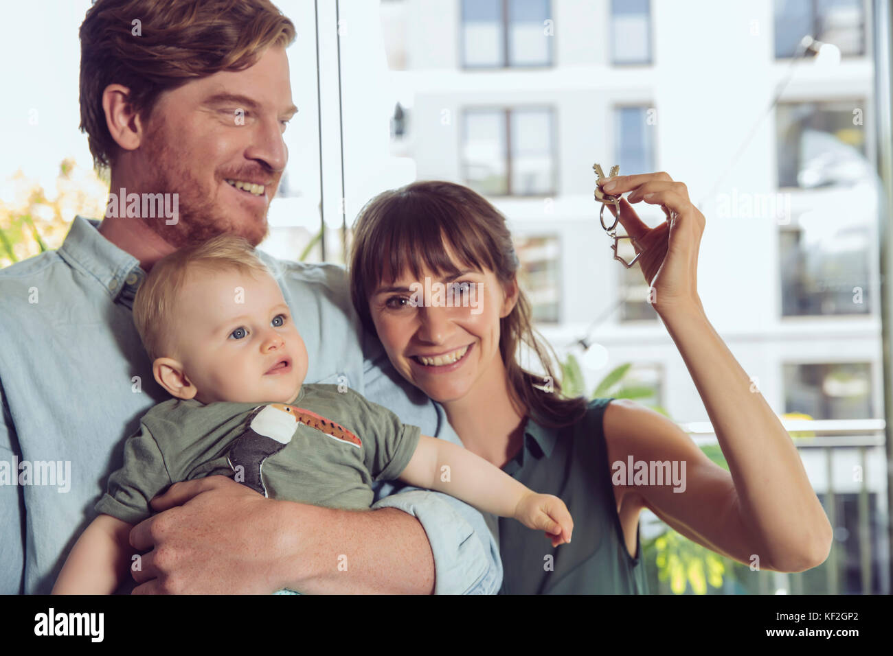 Glückliches Paar mit Baby holding Haus Schlüssel Stockfoto