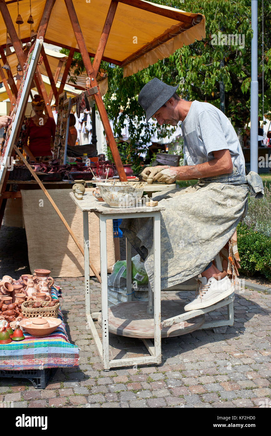 Potter werfen Ton auf der Töpferscheibe Am Marktstand auf dem Platz außerhalb der orthodoxen Kathedrale in Cluj Stockfoto