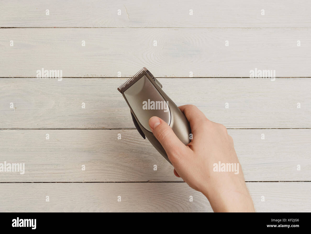 Mann hand Haarschneidemaschinen auf weißem Holz- Hintergrund Stockfoto