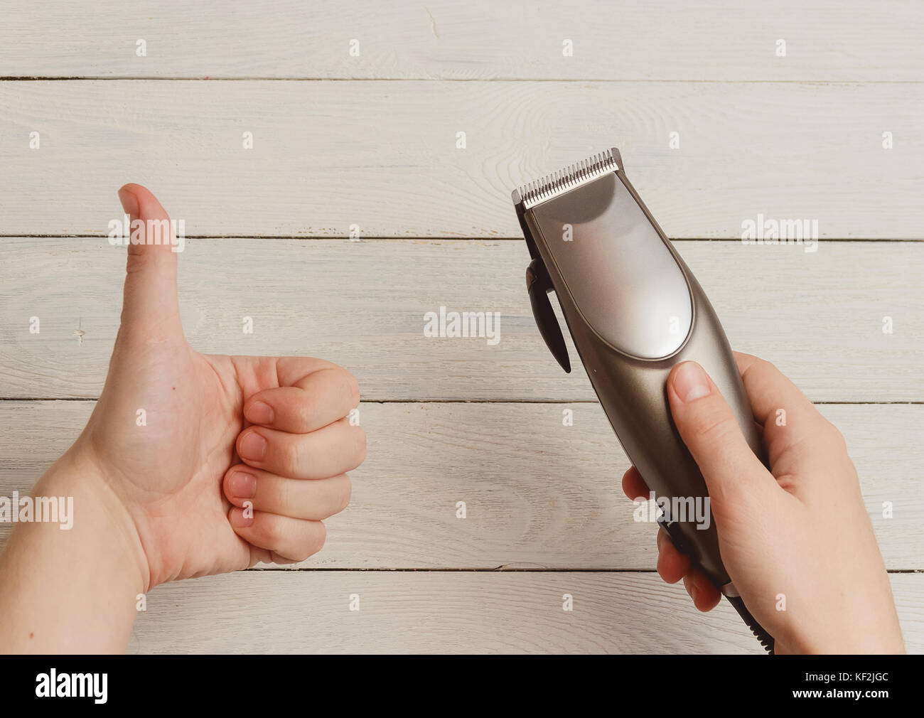 Mann hand Haarschneidemaschinen auf weißem Holz- Hintergrund Stockfoto