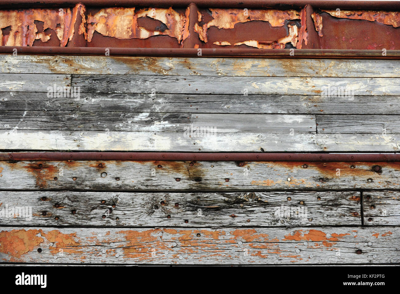 Geschälte Farbe, abgenutzt Nägel und Rost auf verwitterten alten hölzernen Schiffsrumpfes Boards auf siglufjordur Werft dock, North Island Stockfoto