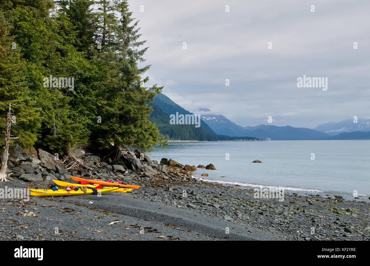 Kajaks am Ufer des Prince William Sound gegen Berge, Alaska, USA Stockfoto