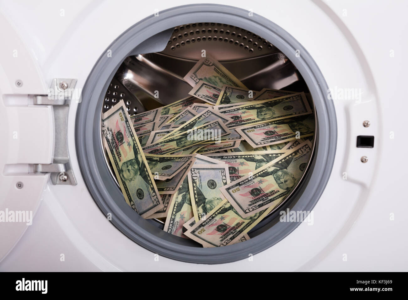 In der Nähe von Pile von schmutzigem Geld in der Waschmaschine platziert Stockfoto