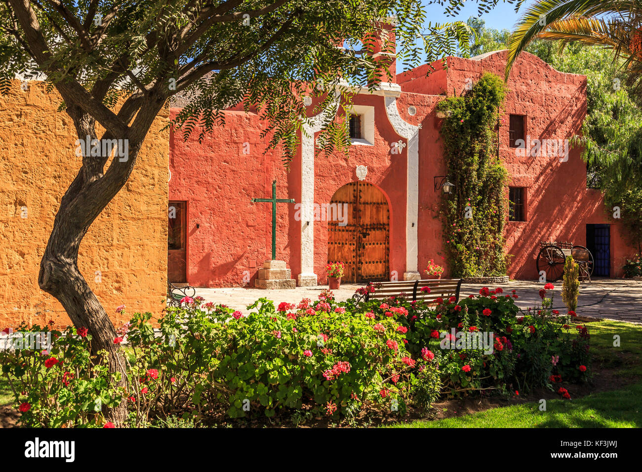 Rote Wände und Tor der spanische katholische Kapelle mit Bäumen und Blumen an der Vorderseite, Arequipa, Peru Stockfoto Rote Wände und Tor der spanische katholische Kapelle mit Bäumen und Blumen an der Vorderseite, Arequipa, Peru Stockfoto