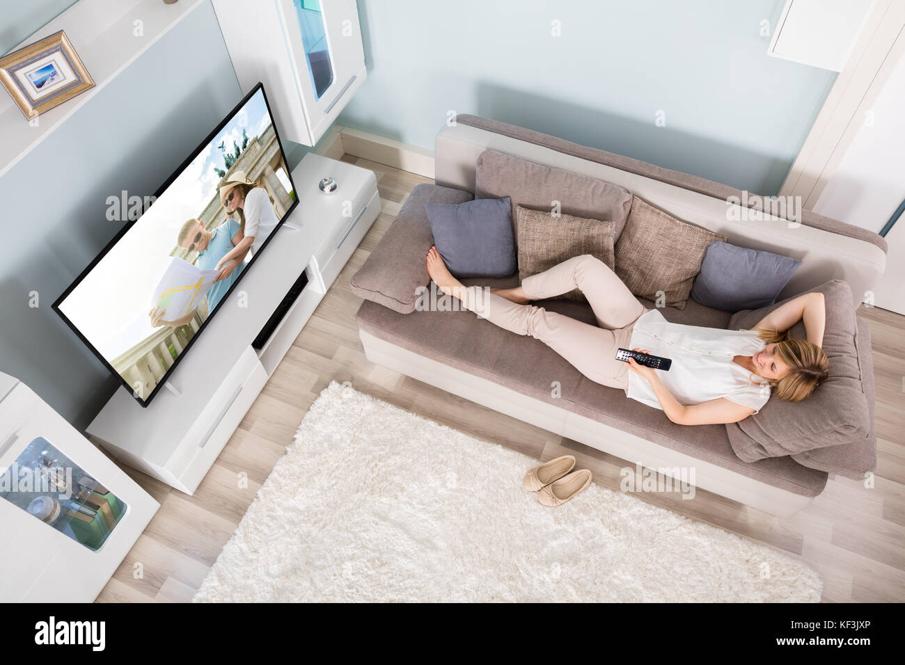 Hohe Betrachtungswinkel und der Frau auf dem Sofa liegend Filme zu Hause im Fernsehen Stockfoto