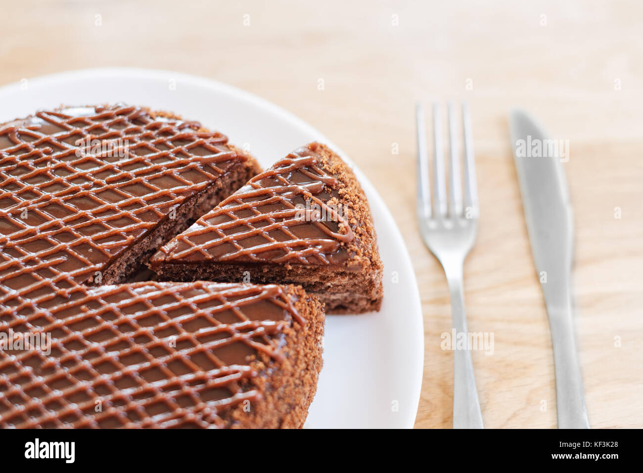 In Scheiben geschnitten serviert leckere Schokoladenkuchen auf hölzernen Tisch Hintergrund. Stoppen Sie die Diät Konzept, Ziel und Ende für gesundes Essen Stockfoto