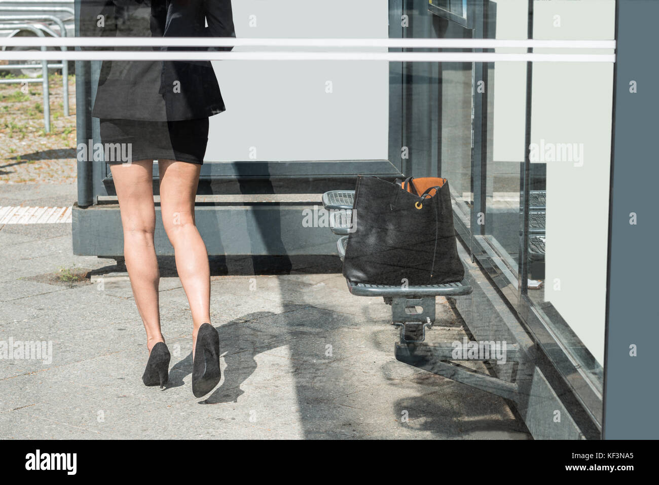 Nahaufnahme einer Geschäftsfrau, die vorwärts gehen mit schwarzen Handtasche auf der Werkbank links Stockfoto