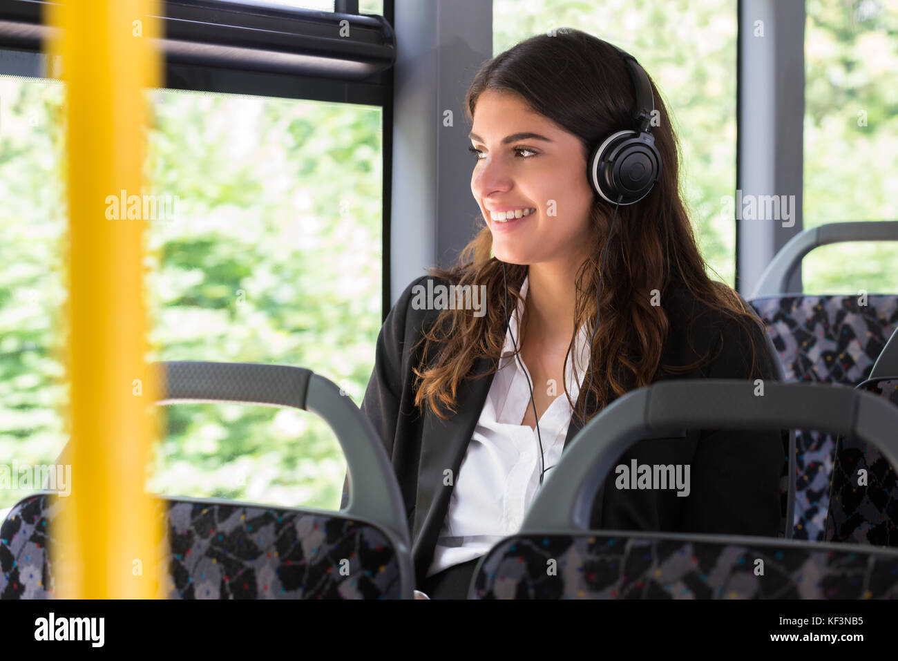 Happy geschäftsfrau Musik hören beim Reisen mit dem Bus Stockfoto