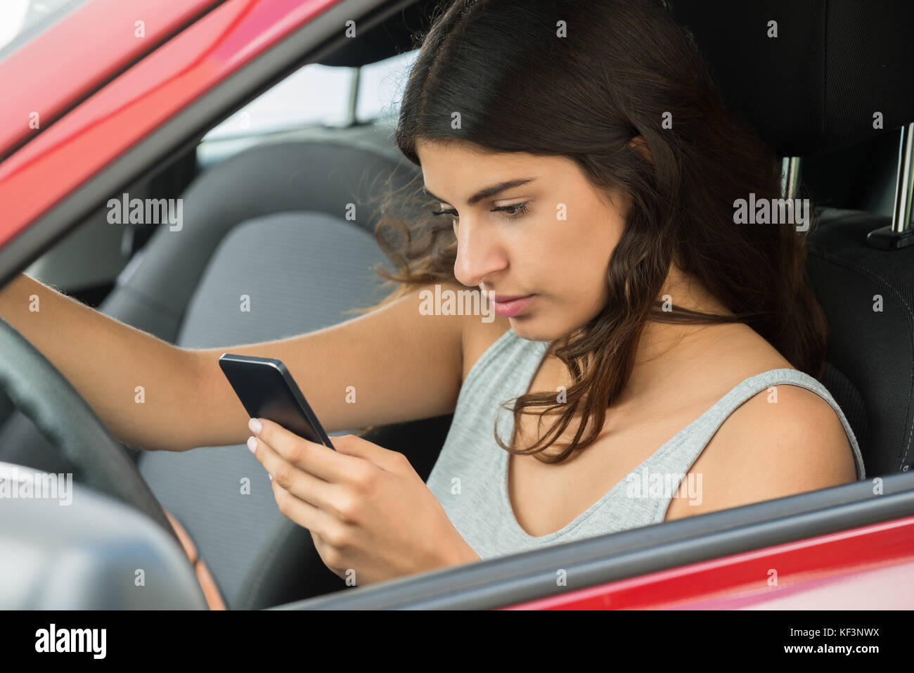 Foto von Frau sitzt im Auto mit Handy Stockfoto