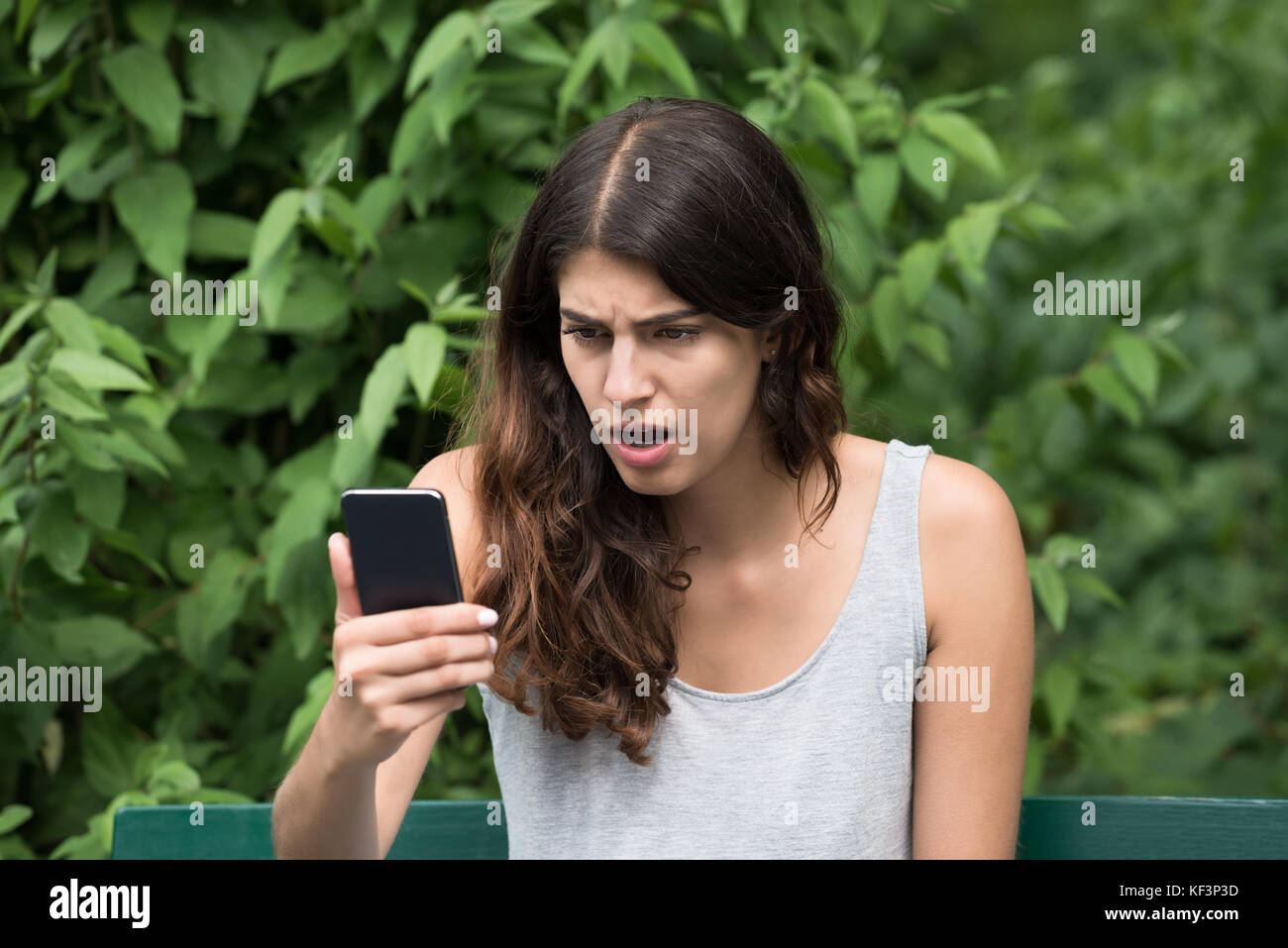 Nahaufnahme der frustrierten jungen Frau am Handy suchen Stockfoto