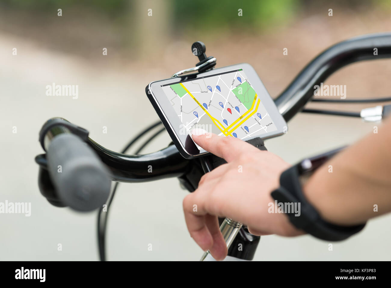 Nahaufnahme der menschlichen Hand zeigen auf Smart Phone mit GPS-Navigation auf dem Fahrrad Stockfoto