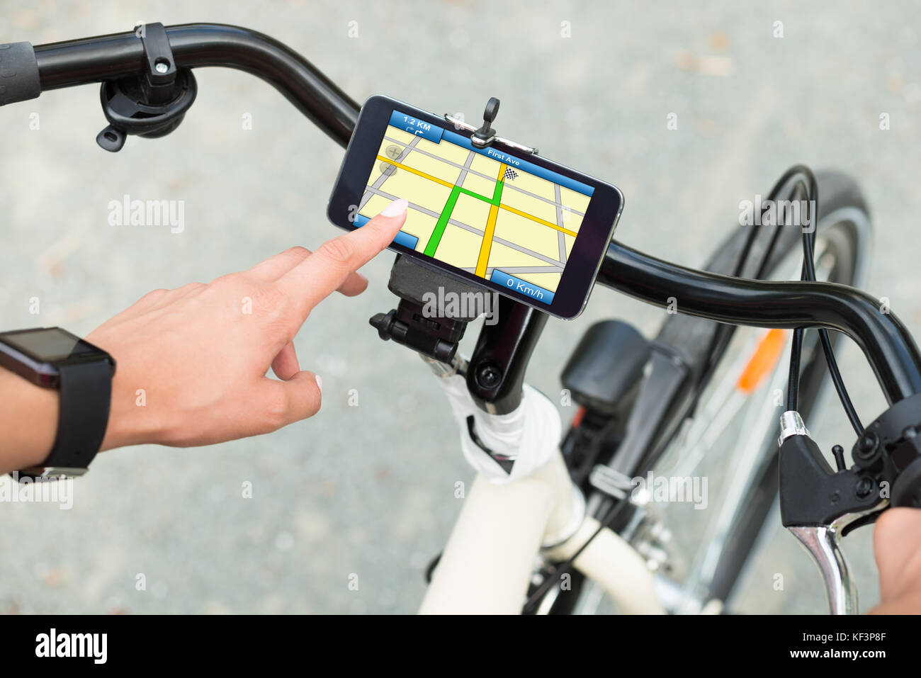 Nahaufnahme der menschlichen Hand zeigen auf Smart Phone mit GPS-Navigation auf dem Fahrrad Stockfoto