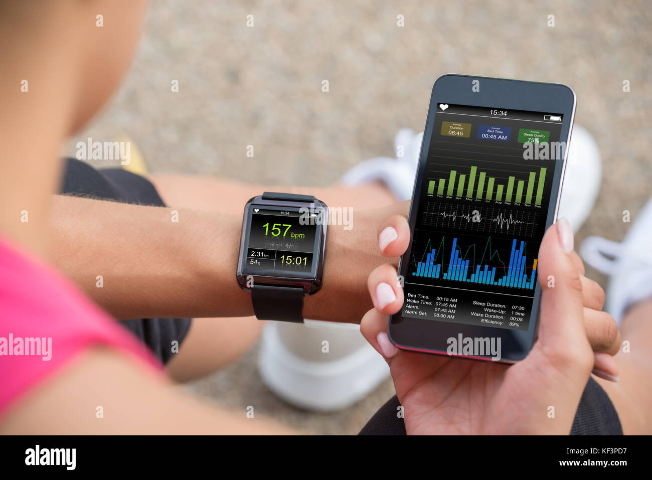 Läuferin auf Ihr Handy und Smart Watch Pulsmesser Stockfoto