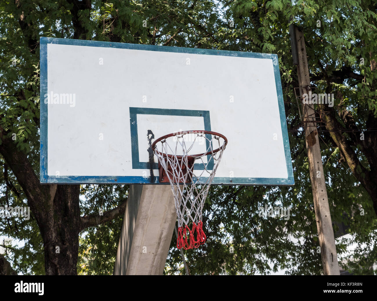 Alte Basketballkorb auf dem Beton Pol in der Nähe des großen Baum des  öffentlichen Park Stockfotografie - Alamy