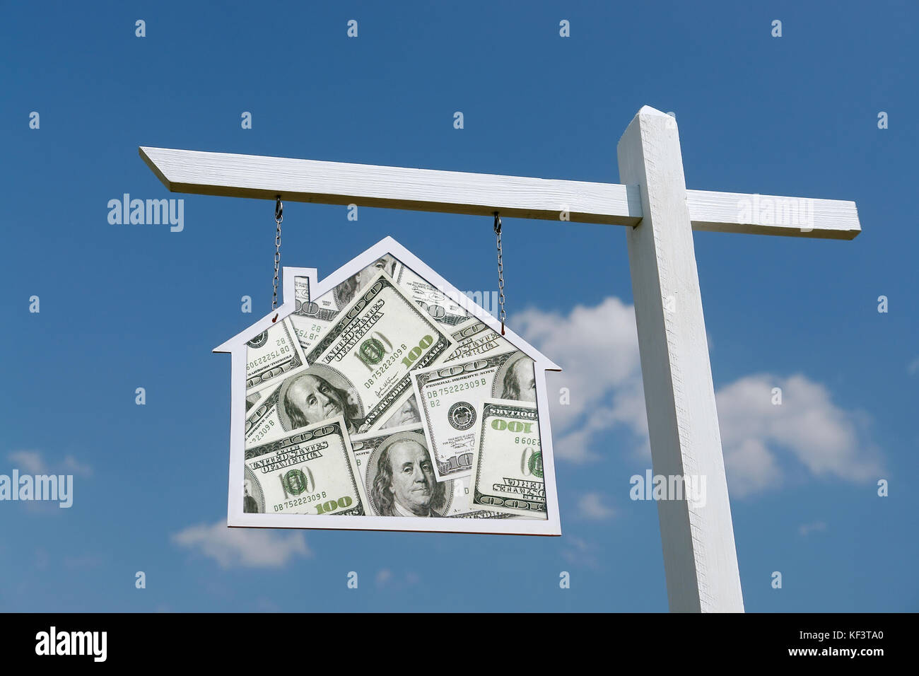 Weiß hölzernen Pfosten mit Haus geformte Zeichen mit hundert Dollar haufen Hintergrund über blauen Himmel Stockfoto