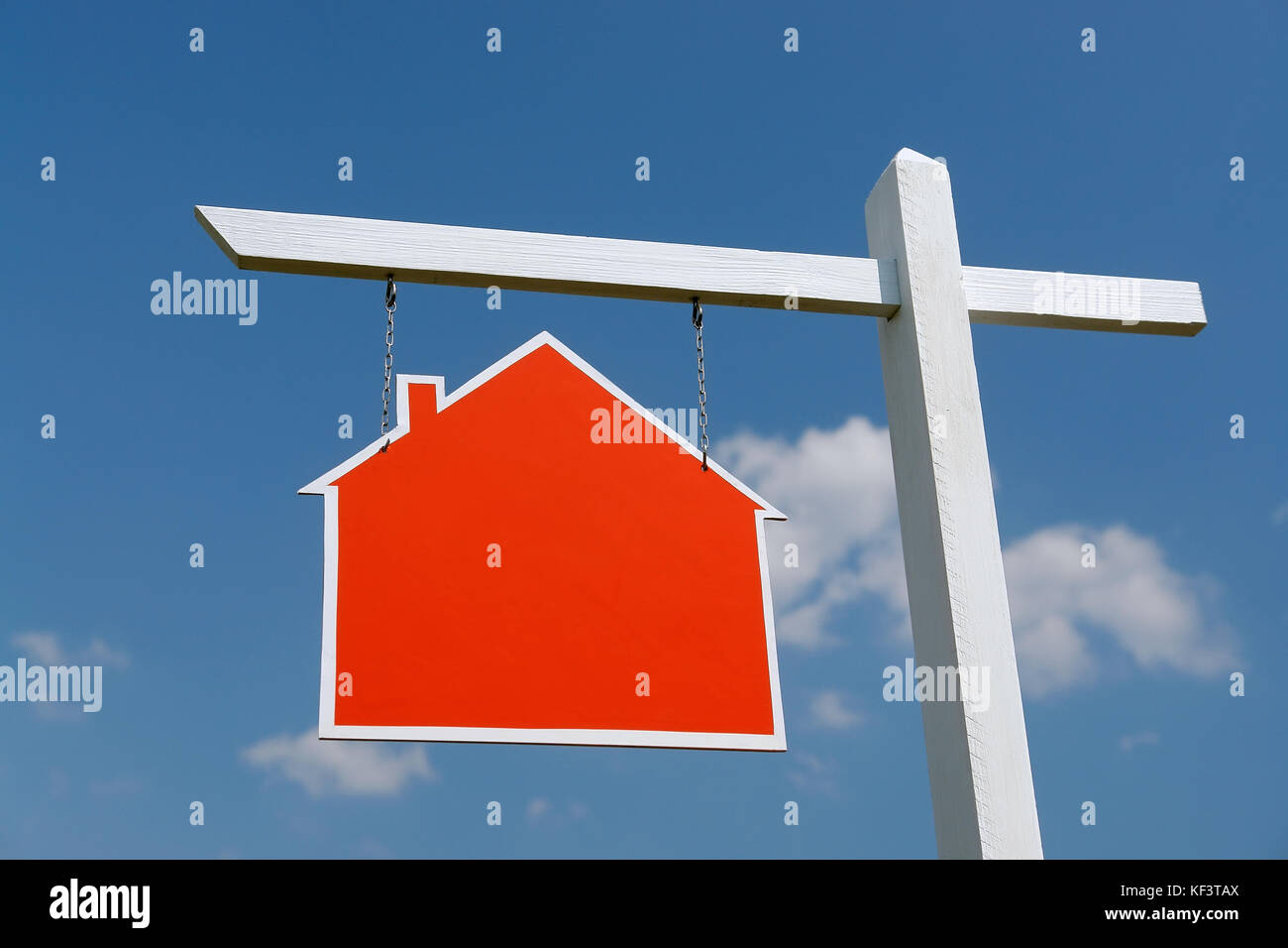 Weiß hölzernen Pfosten mit leeren roten Haus-förmiges Schild über blauen Himmel Stockfoto