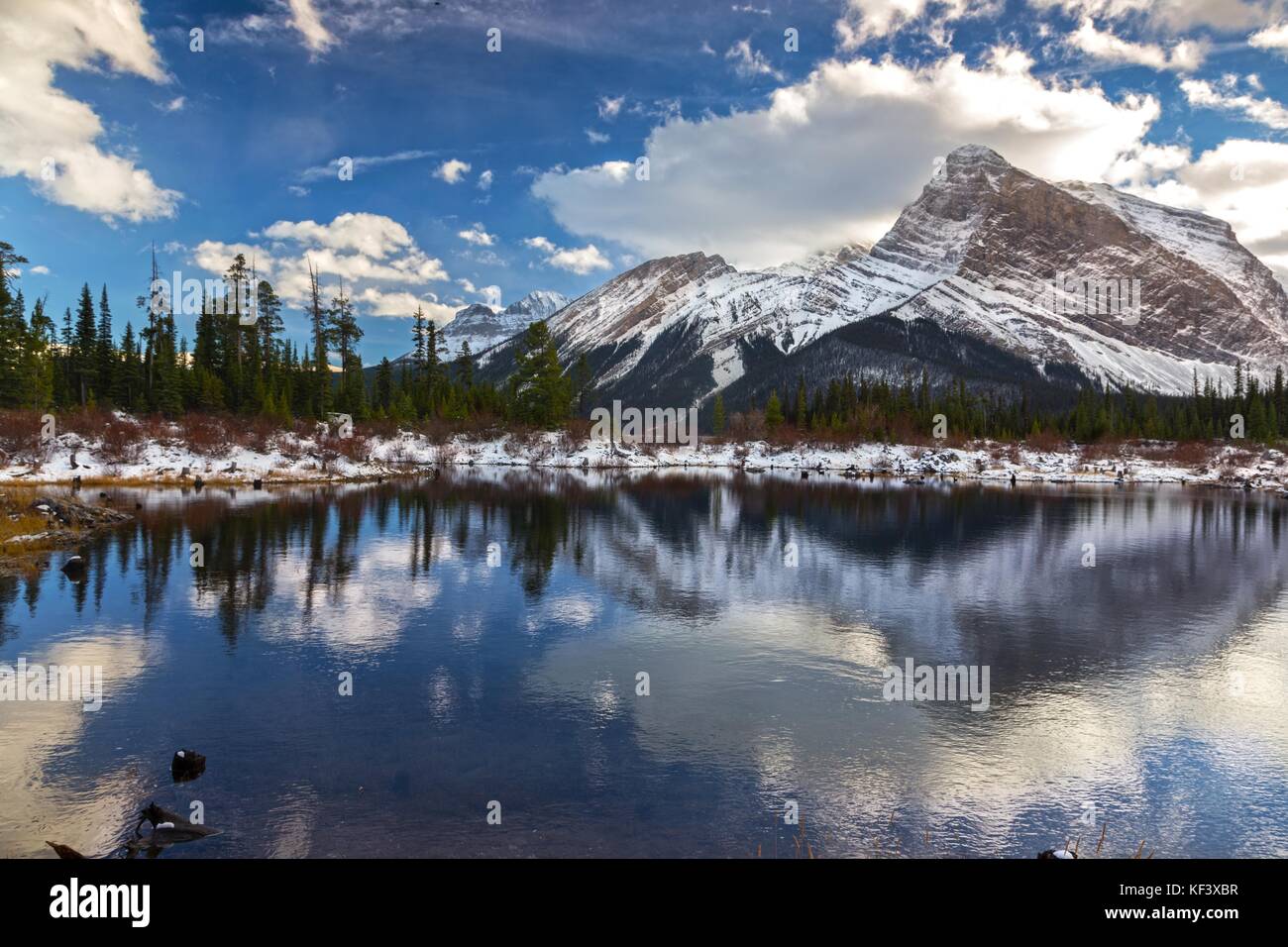 Berggipfel und dramatische Himmelswolken spiegeln sich im ruhigen Wasser des Sees wider. Malerische Landschaft Der Kanadischen Rockies Kananaskis Country, Alberta, Peter Lougheed Park Stockfoto