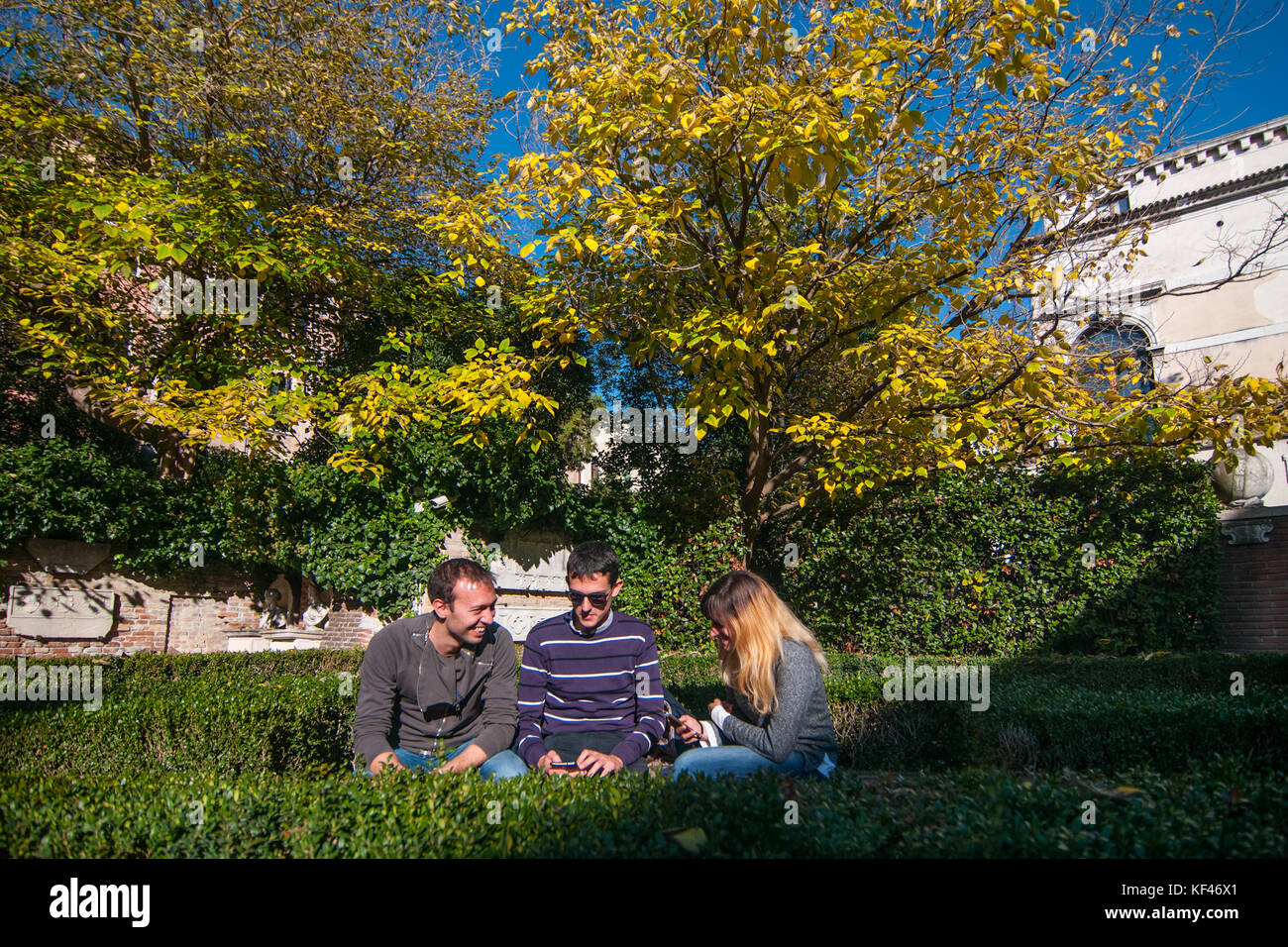 Venedig, Italien, Oktober 2017. Jungs und Mädels miteinander sprechen im Garten von Ca Rezzonico, wo die Bäume und Pflanzen ändern sich Laub in Ven Stockfoto