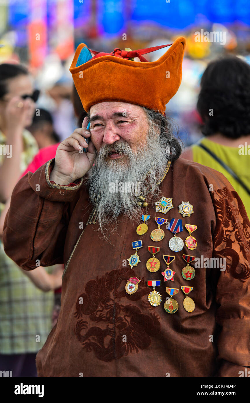 Älterer Mann mit Bart, Kopf - Kleid und Medaillen spricht auf ein Mobiltelefon, Ulaanbaatar, Mongolei Stockfoto