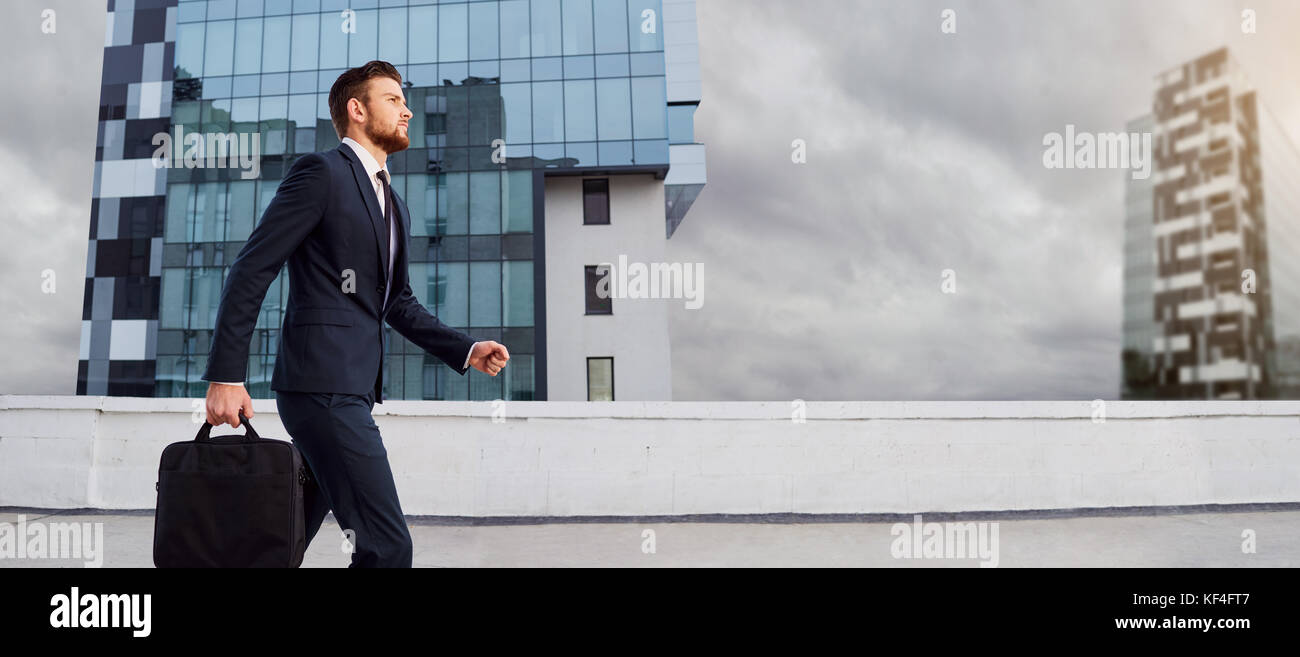 Geschäftsmann ist Laufen mit einer Tasche auf die Stadt. Stockfoto