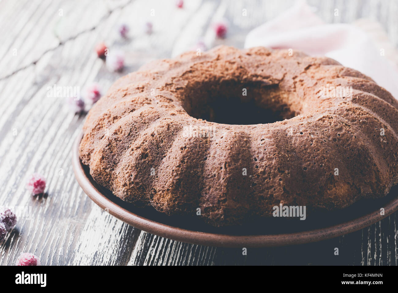 Bundt Cake mit kandierte Preiselbeeren auf Holzbrett. hausgemachte Herbst und Winter gemütliches Dessert auf rustikalen Tisch Stockfoto