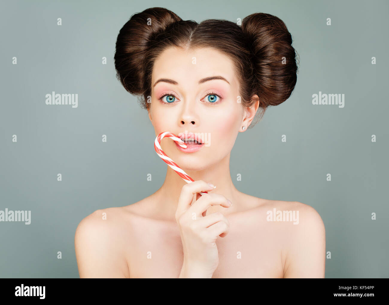 Beauty Fashion Portrait von Modell Frau essen bunten Lutscher. nettes Mädchen mit lustiger Frisur auf grauem Hintergrund Stockfoto Beauty Fashion Portrait von Modell Frau essen bunten Lutscher. nettes Mädchen mit lustiger Frisur auf grauem Hintergrund Stockfoto