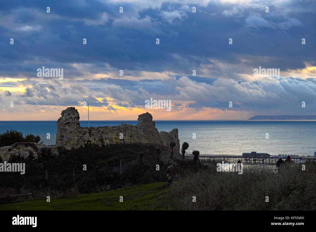 Nach Sturm Brian einem Windgepeitschten Sonnenuntergang über Hastings Castle, mit schweren Gewitterwolken über der fernen Beachy Head, East Sussex, England, Großbritannien Stockfoto